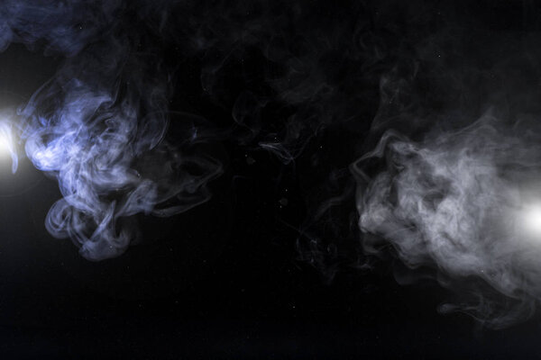 Grey smoky swirls and lights on black background with copy space