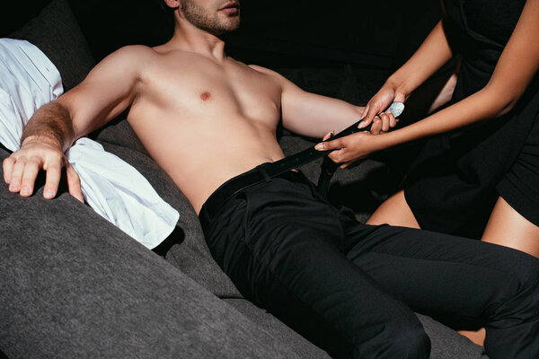 обрезанный снимок многорасовой сексуальной пары в черной одежде на диване
