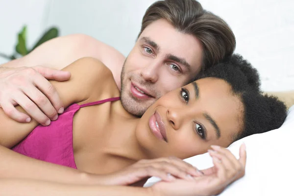 Πορτρέτο Της Πολυεθνικής Νεαρό Ζευγάρι Στην Αγάπη Ξαπλωμένη Στο Κρεβάτι — Δωρεάν Φωτογραφία