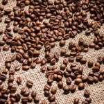 High angle view of roasted coffee beans spilled on sackcloth