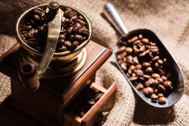 close-up shot of vintage coffee grinder with scoop on sackcloth clipart