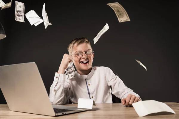 Menino Sorrindo Sentado Mesa Com Laptop Notas Dólar Fundo Cinza — Fotografia de Stock