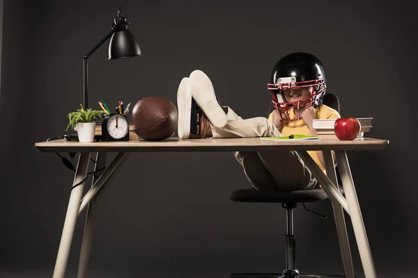 Smiling Schoolboy American Football Helmet Sitting Legs Table Ball Books — Stock Photo, Image