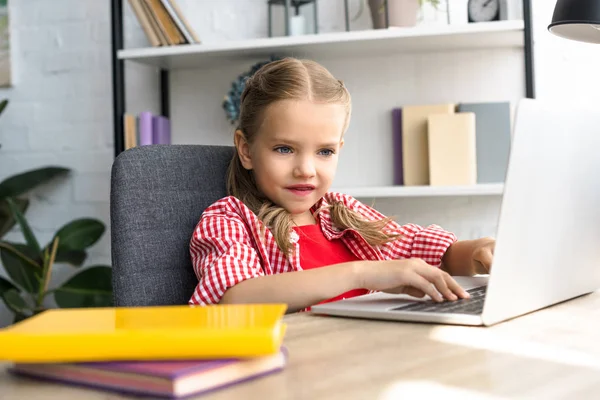 自宅のテーブルでノート パソコンを使用して小さな子供の肖像画 — ストック写真