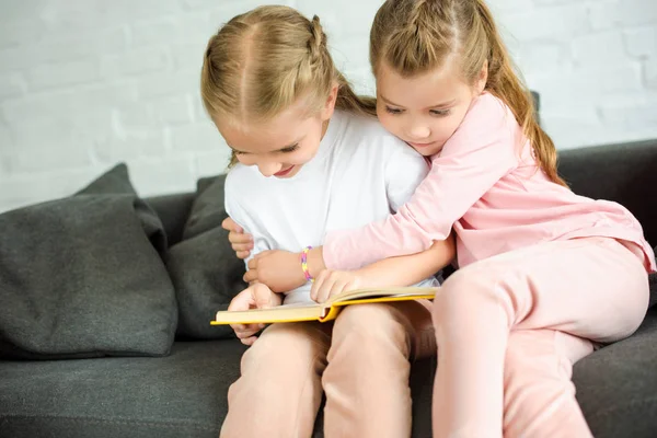 Schattige Kleine Zusters Lezen Boek Samen Sofa Thuis — Gratis stockfoto