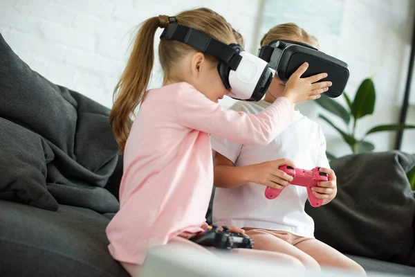 自宅のソファの上のビデオゲームを再生仮想現実ヘッドセットの子供の表示を隠されて — ストック写真