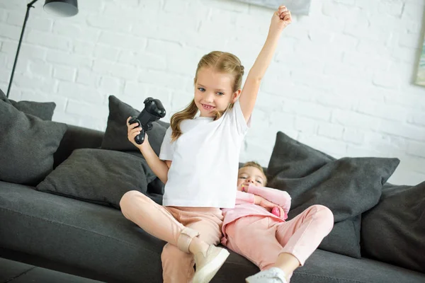 Niedliche Kleine Schwestern Mit Gamepads Beim Gemeinsamen Videospiel Hause — kostenloses Stockfoto