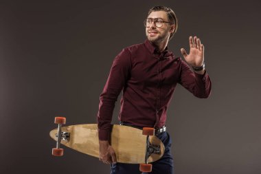longboard tutarak ve uzak seyir siyah izole gözlük yakışıklı gülümseyen adam 