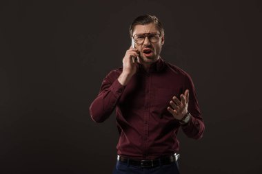Kızgın adam yanında siyah izole smartphone konuşurken gözlük