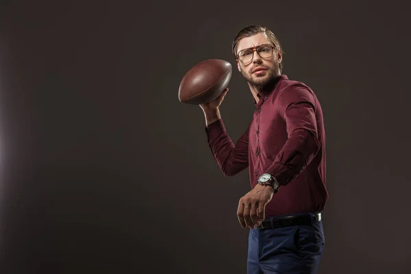 Hombre Serio Gafas Lanzando Pelota Rugby Mirando Cámara Aislada Negro — Foto de stock gratuita