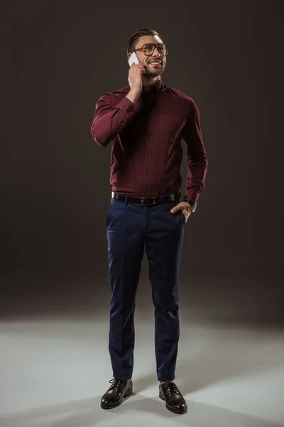 Sonriente Hombre Hablando Por Teléfono Inteligente Mirando Hacia Otro Lado — Foto de stock gratuita