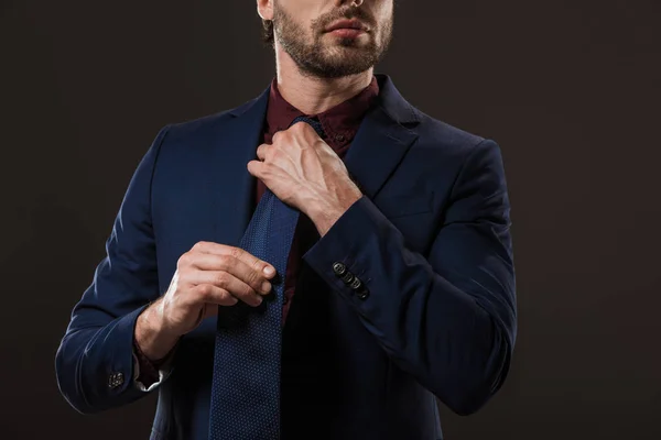 Colpo Ritagliato Elegante Uomo Affari Regolazione Cravatta Isolato Nero — Foto stock gratuita