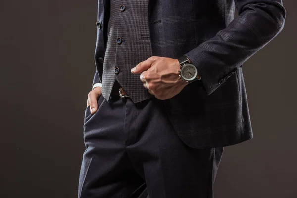 裁剪拍摄的男子穿着时髦西装戴着手表和站在口袋里孤立黑色的手 — 图库照片
