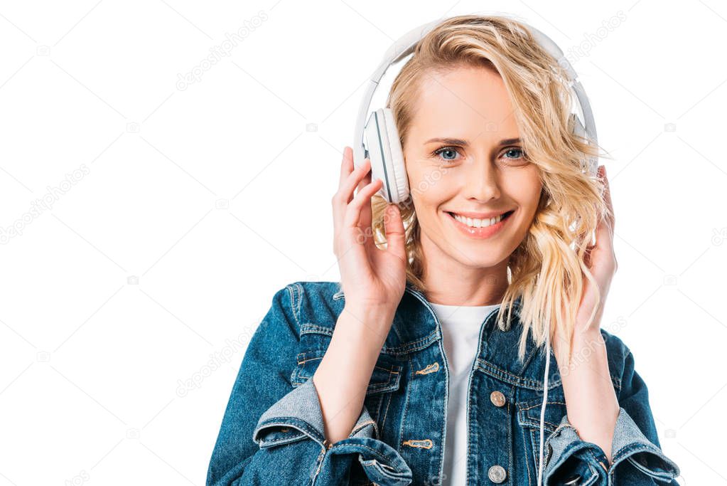 beautiful woman listening to music with headphones and looking at camera isolated on white