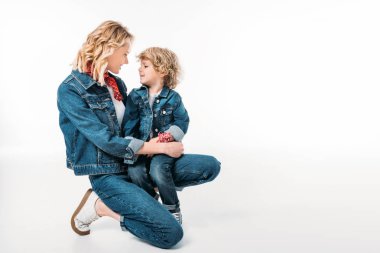 mutlu anne ve çömelme ve birbirlerine beyaz izole bakarak oğlu