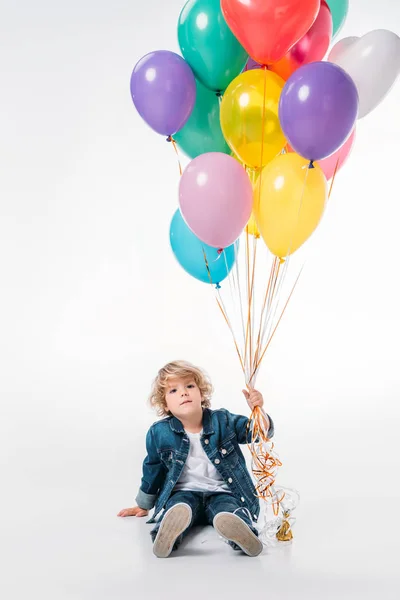Rozkošný Chlapec Sedí Drží Svazek Balonků Bílém — Stock fotografie