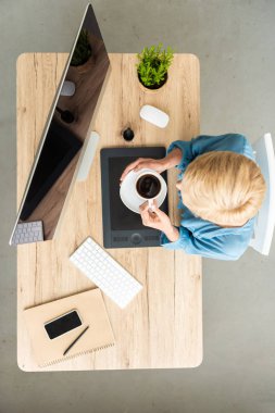 kadın Freelancer kahve masada grafik tablet, akıllı telefon ve bilgisayar ile Genel müdürlükte holding genel gider görünümü 