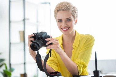 kadın fotoğrafçı photostudio masada kamera tutarak portresi 