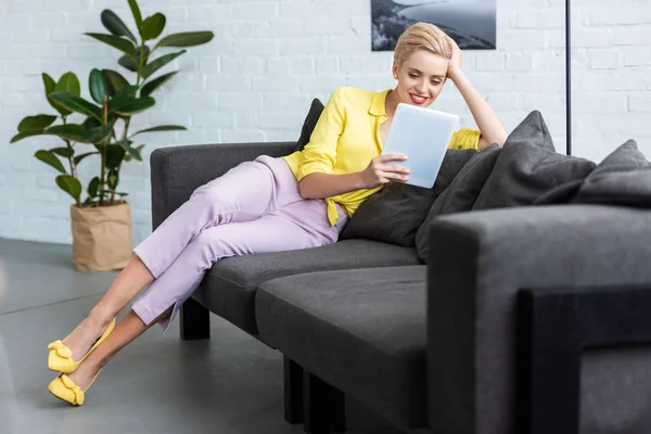 Sorrindo Jovem Mulher Elegante Usando Tablet Digital Sofá Casa — Fotografia de Stock