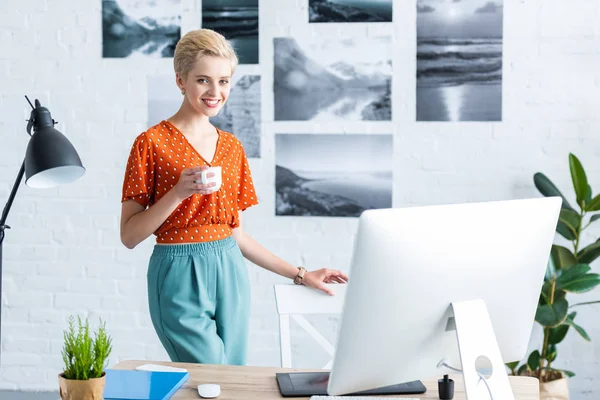 Elegante Freelancer Mujer Sosteniendo Taza Café Cerca Mesa Con Tableta — Foto de Stock