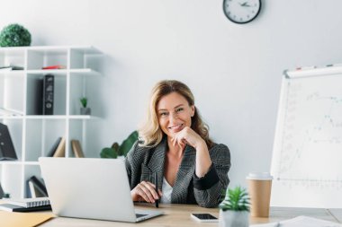 laptop ile masada oturan ve kamera Office bakarak çekici işkadını