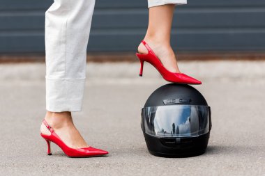 kadının motosiklet kask Caddesi üzerinde bacak koyarak kırmızı topuklu kırpılmış görüntü 
