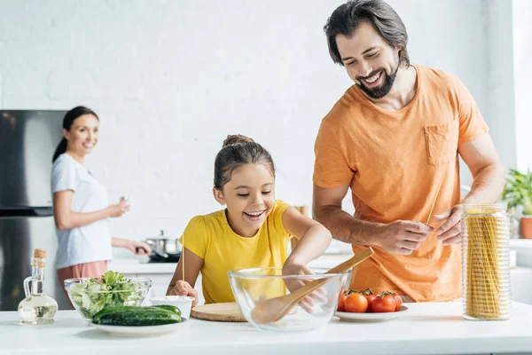 父亲和女儿做饭 而母亲站在厨房的背景模糊 — 图库照片