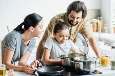 gülümseyen genç aile birlikte mutfak yemek