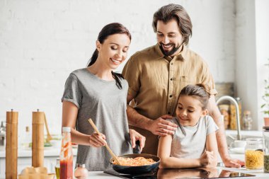 küçük kızı mutfakta omlet pişirme ile güzel aile