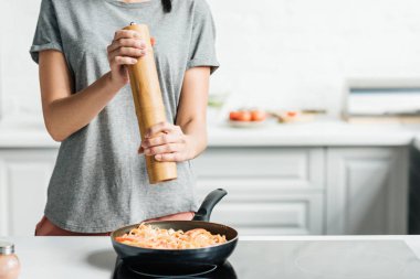 biber kızartma tavası üzerinde yemek makarna ekleme kadın görüntüsünü kırpılmış