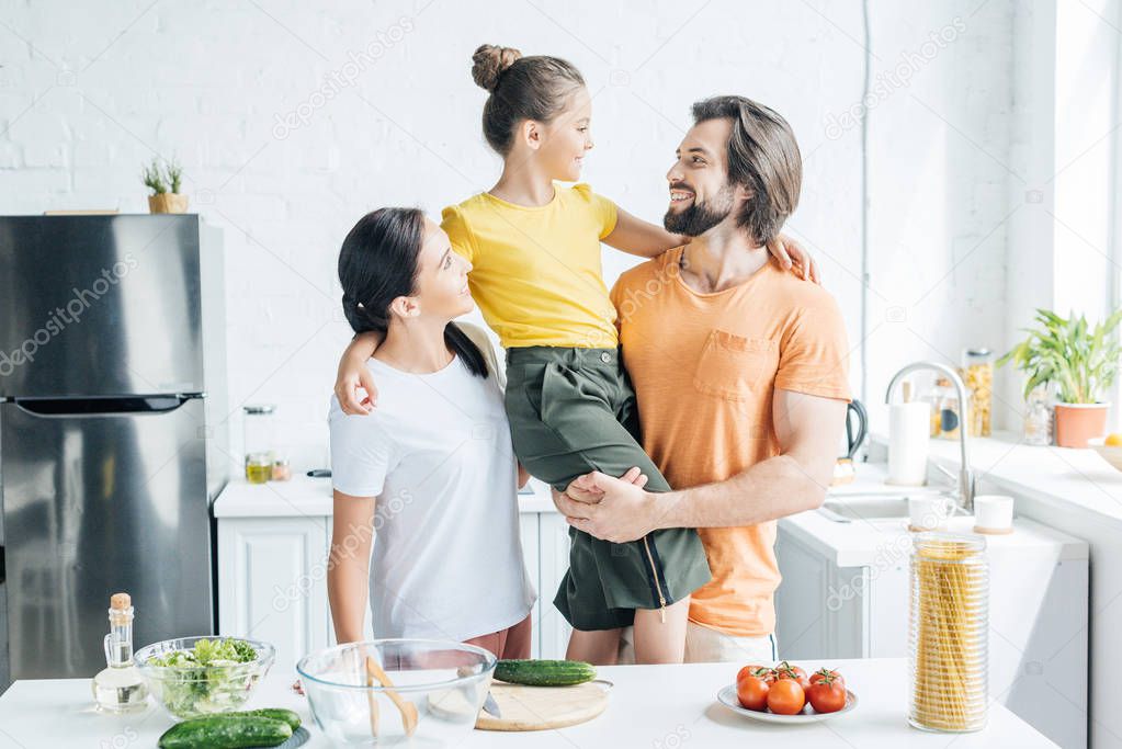 beautiful young family embracing at kitchen