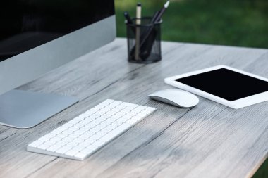 seçici odak dijital tablet ve açık havada masada boş ekranlı bilgisayar 