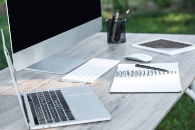 dizüstü bilgisayar, ders kitabı, dijital tablet ve tablo açık havada bilgisayarda seçici odak 