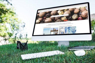 ders kitabı ve bilgisayarın açık havada çimenlerin üzerinde depositphotos.com Web sitesi ile seçici odak 
