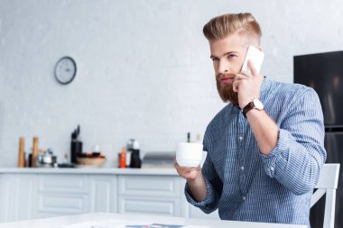 Smartphone ile konuşmak ve kahve evde tutan yakışıklı delikanlı