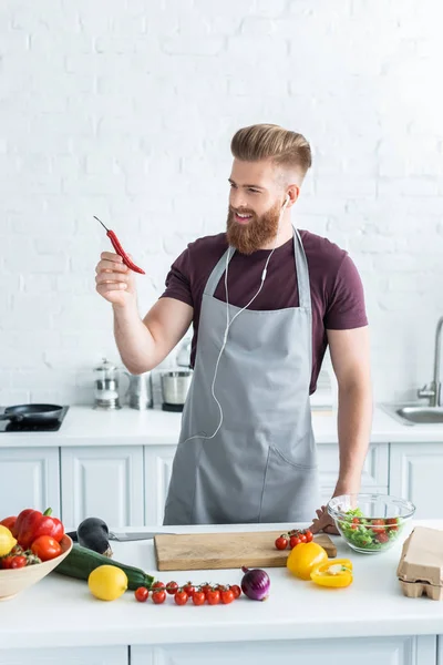 Yakışıklı Gülümseyen Adam Kulaklık Müzik Dinleme Mutfakta Yemek Yaparken Chili — Stok fotoğraf