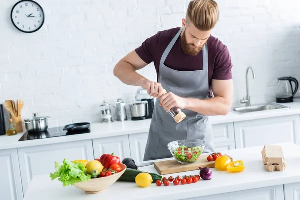 Visão Alto Ângulo Belo Jovem Avental Temperando Salada Legumes — Fotografia de Stock