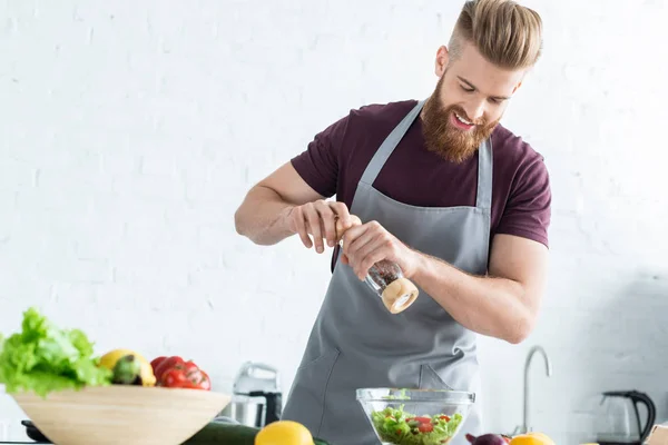 Handsome Smiling Young Man Apron Spicing Vegetable Salad — Stock Photo, Image