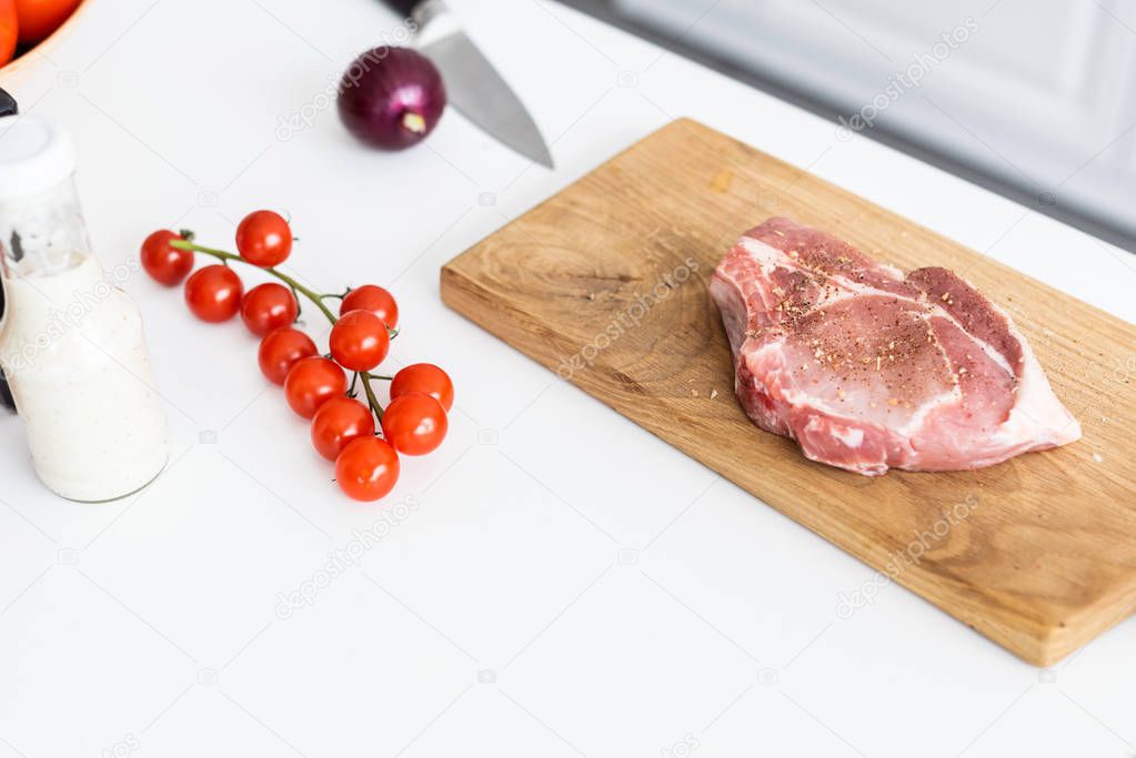 close-up view of delicious raw steak on wooden cutting board