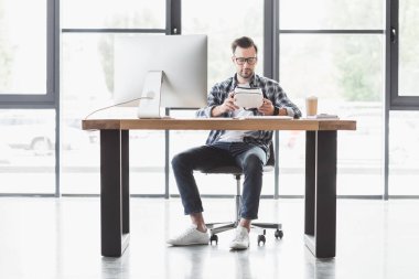 sanal gerçeklik kulaklık işyerinde otururken tutan yakışıklı genç programcı görünümünü tam uzunlukta
