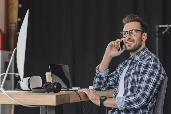 Smiling Young Man Eyeglasses Talking Smartphone Looking Away Workplace — Stock Photo, Image