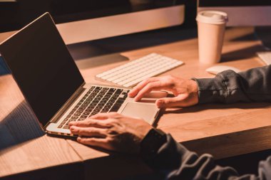 cropped shot of young programmer using laptop with blank screen at night clipart