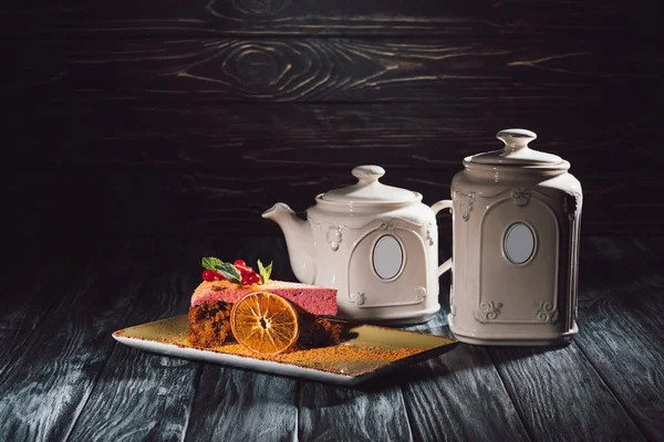 木桌上的盘子和茶壶上放满浆果的胡萝卜蛋糕 — 图库照片