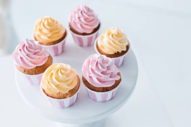 selective focus of delicious cupcakes on stand at table  clipart