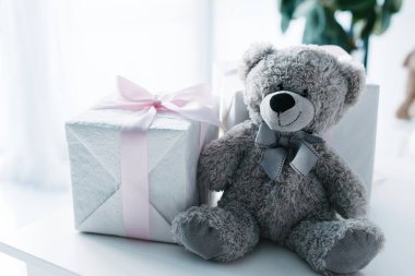 selective focus of teddy bear with gift boxes on table 