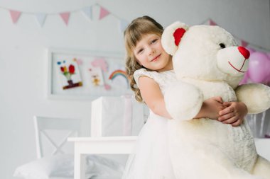 İyi ki doğdun çocuk oyuncak ayı kucaklayan beyaz elbiseli