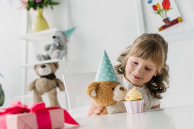 şirin Doğum günü çocuğu cupcake masada tarafından koni içinde oyuncak ayı besleme 