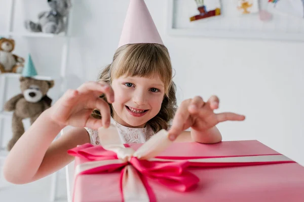 快乐的孩子在锥体打开生日礼物盒和看照相机 — 图库照片