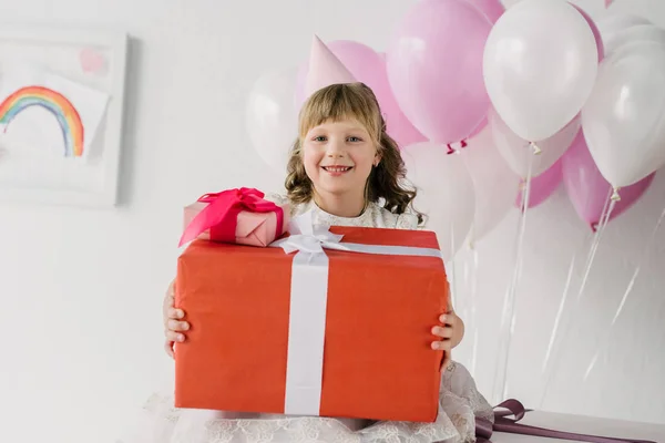 Little Birthday Girl Cone Holding Gift Boxes Looking Camera — Free Stock Photo