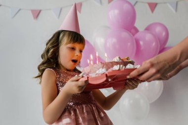 Doğum günü çocuğu mumları üfleme sırasında anne holding pastadan kırpılmış görüntü 
